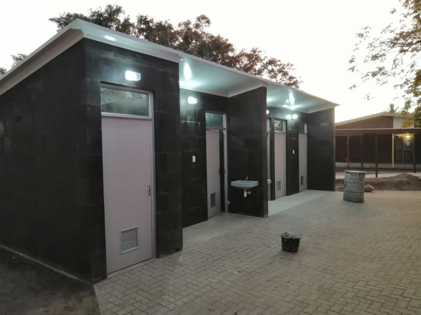 Seitenansicht der Sanitäranlage mit Waschbecken und Türen zu den Toiletten